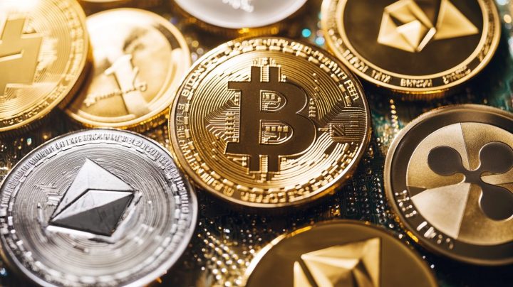 ビットコイン、イーサリアム、リップル、ライトコインなど複数の暗号資産の物理コインが重なり合って配置されている